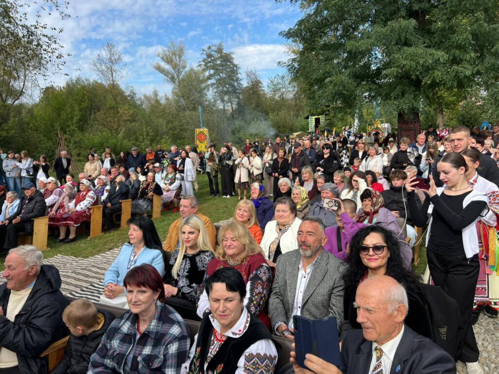Люди на масовому заході на природі, яскравий одяг.