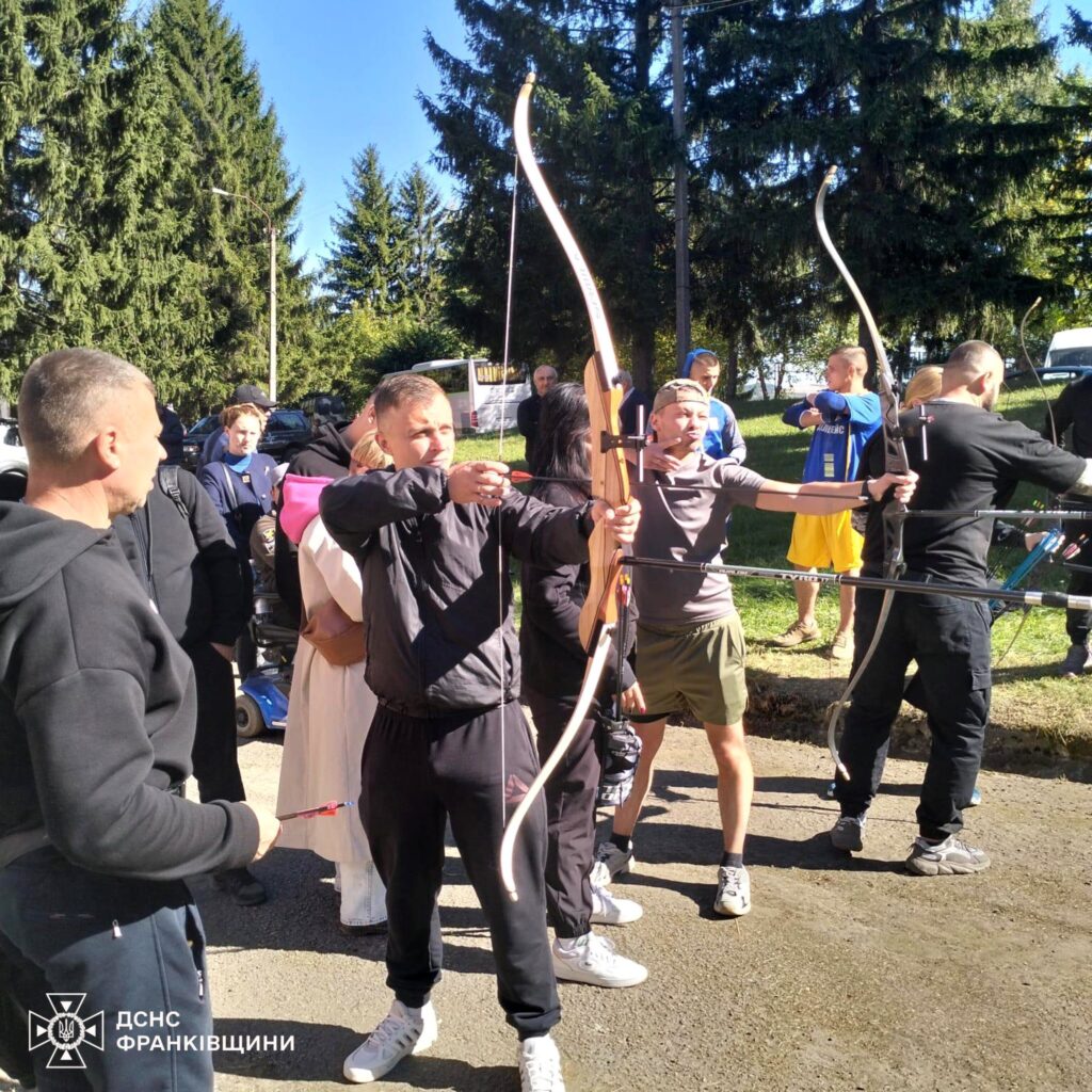 Люди займаються стрільбою з лука на вулиці.