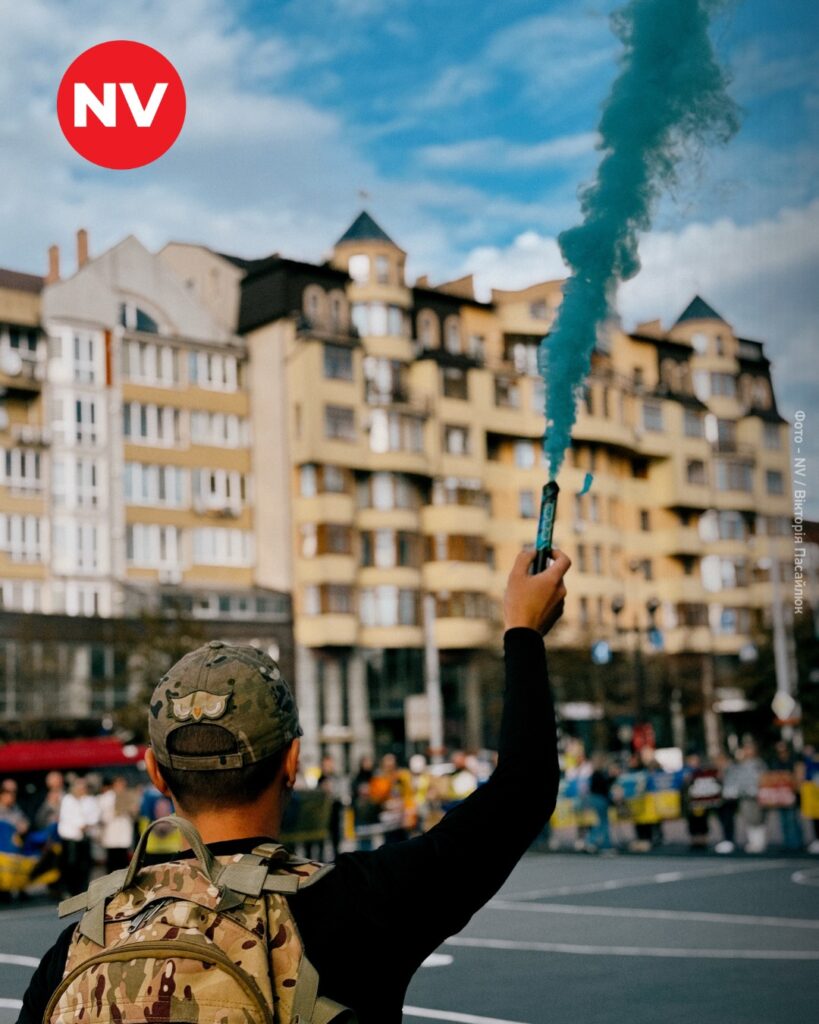 Людина з димовою шашкою на міській площі.