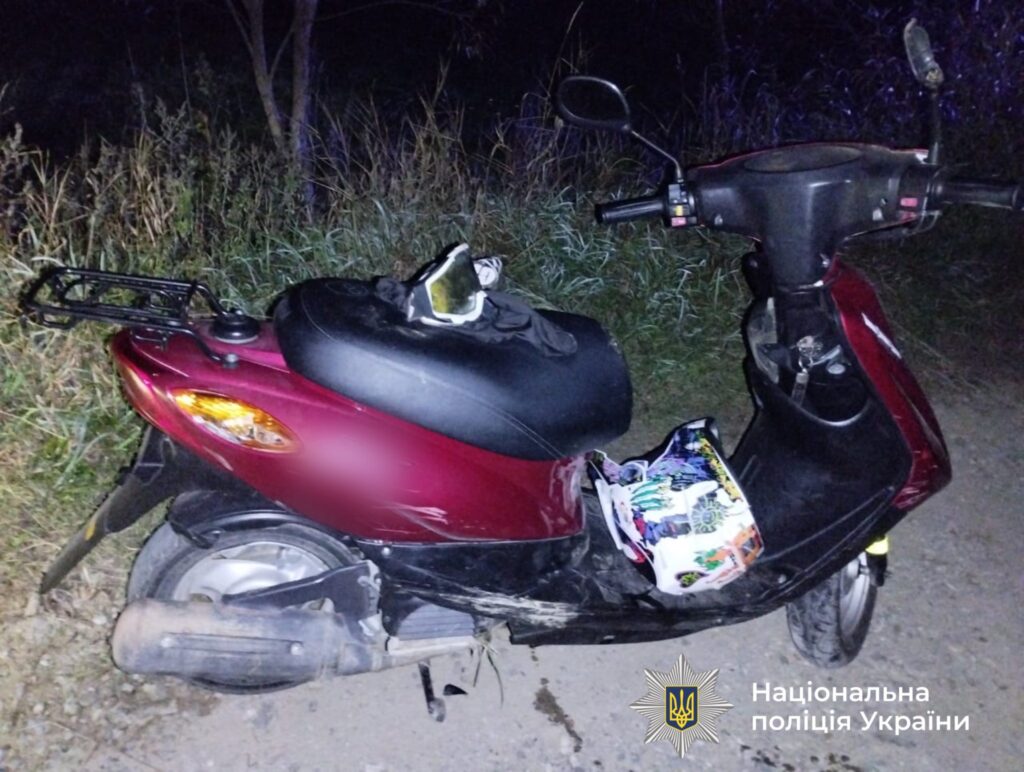 Моторолер стоїть біля дороги вночі, поліція