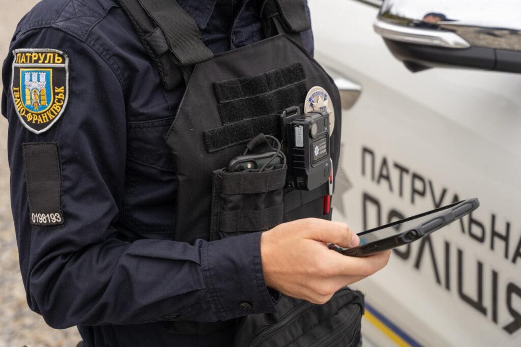 Поліцейський використовує планшет для роботи на вулиці.