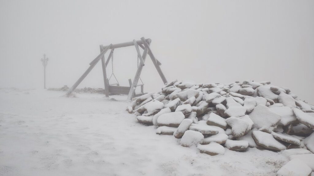 Засніжені гойдалки та камені в тумані