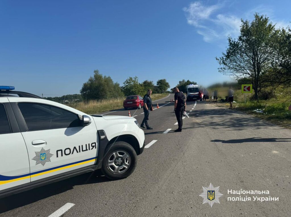 Поліцейське авто і працівники на дорозі