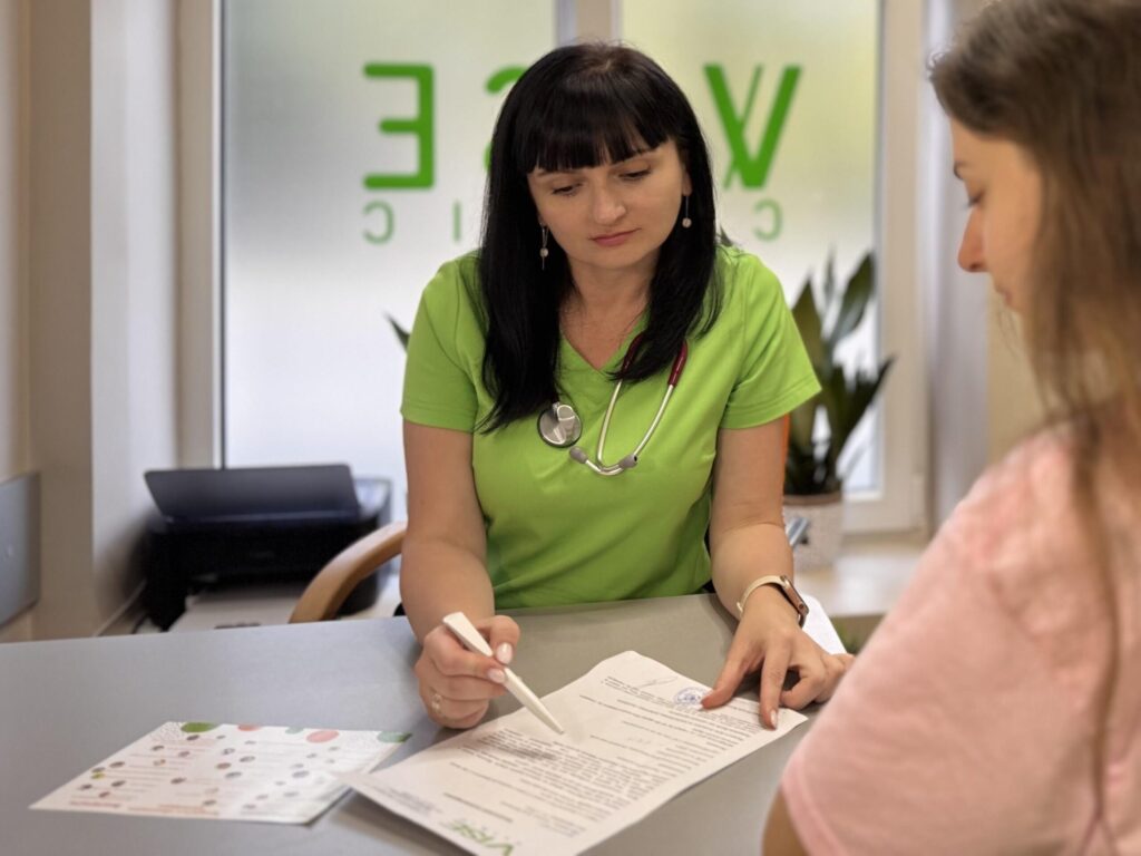 Лікар пояснює документ пацієнтці в клініці.