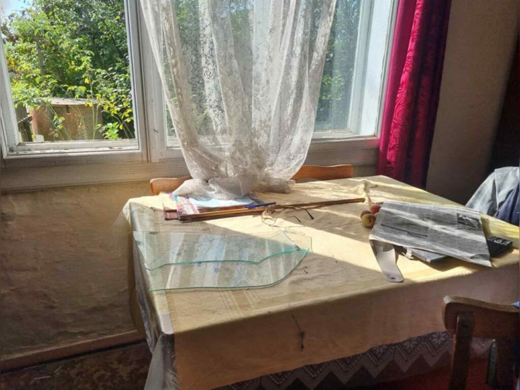 Стіл біля вікна з газетами й фруктами.