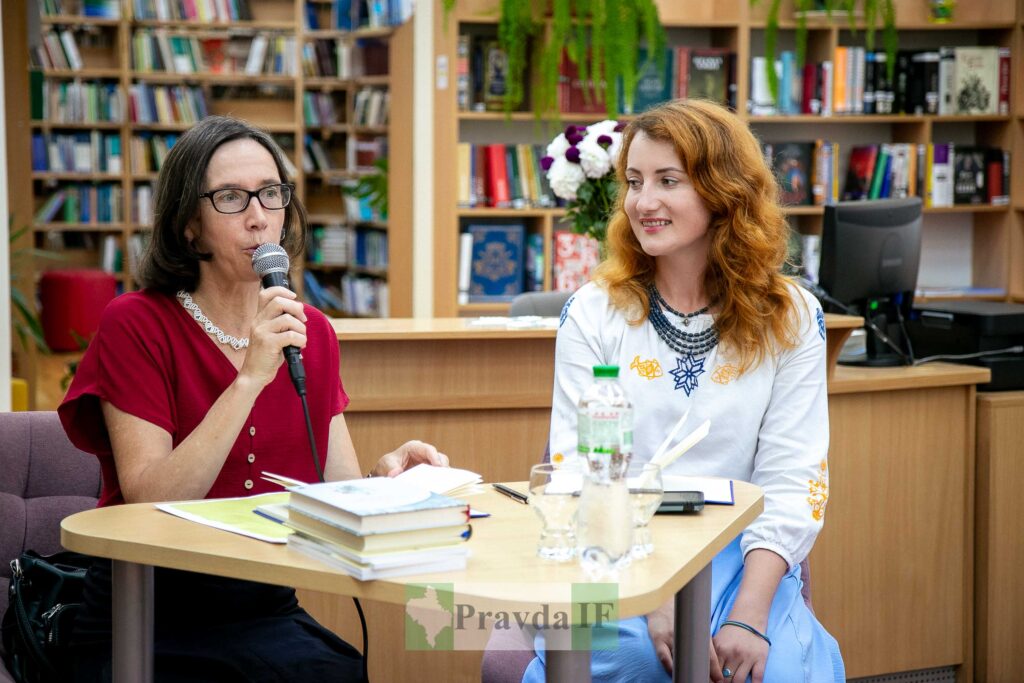Презентація книг у бібліотеці, дві жінки спілкуються.