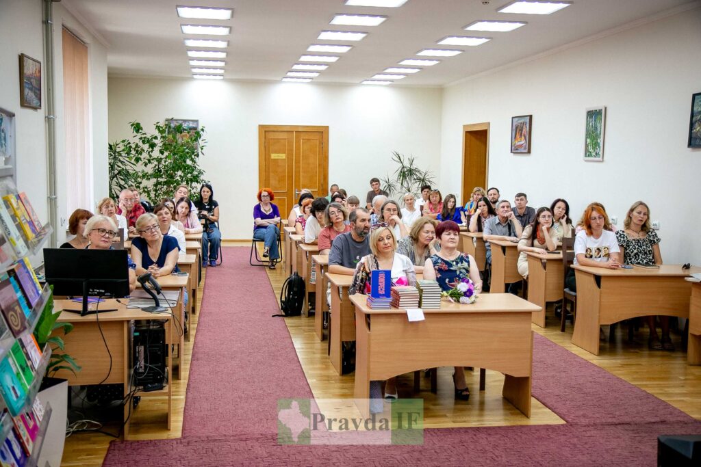Семінар у бібліотеці, люди сидять за столами.