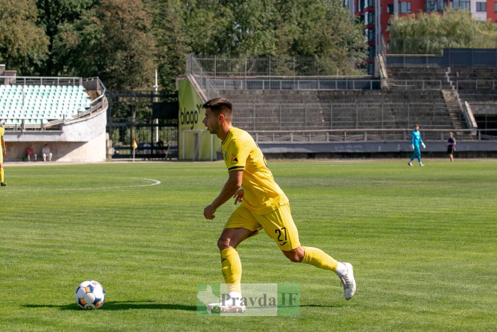 Футболіст у жовтій формі грає на полі