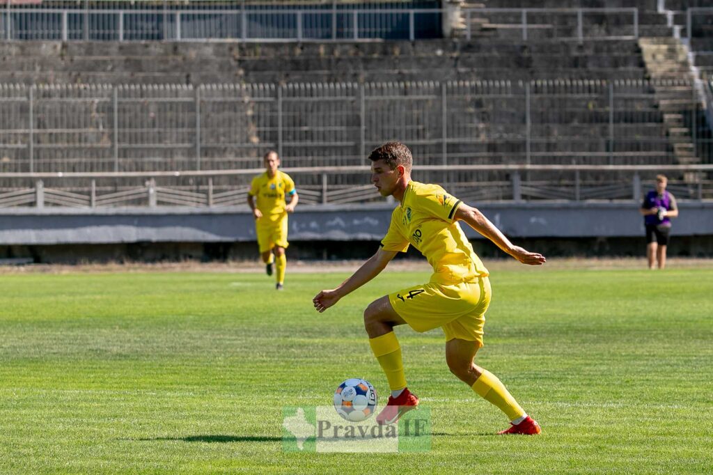 Футболіст в жовтій формі на полі