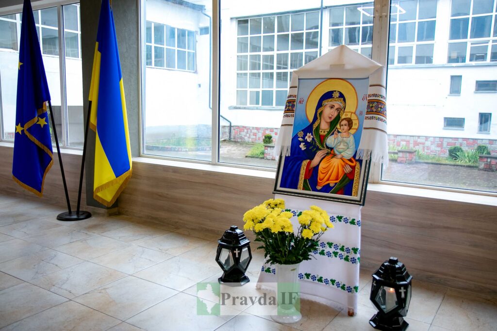 Ікона Богородиці біля прапорів і квітів