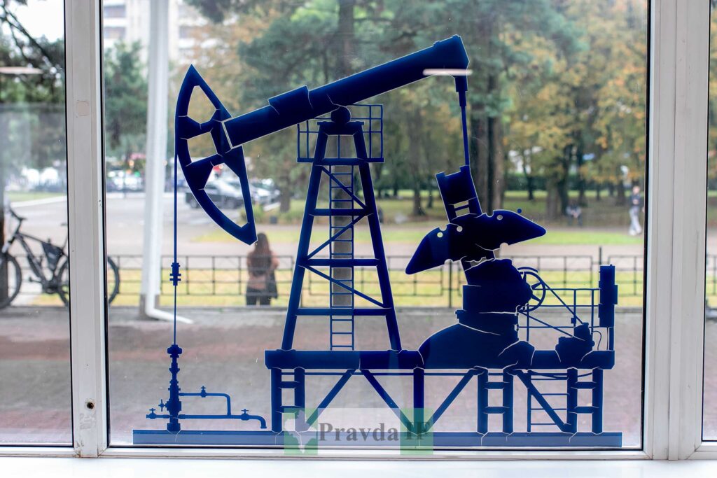 Силует нафтової помпи на прозорому вікні.
