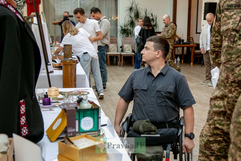 Виставка, чоловік у візку, люди в залі