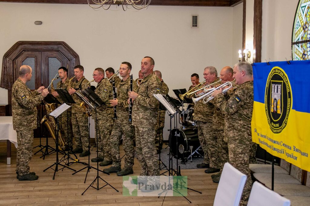 Оркестр у військовій формі грає музику в залі.