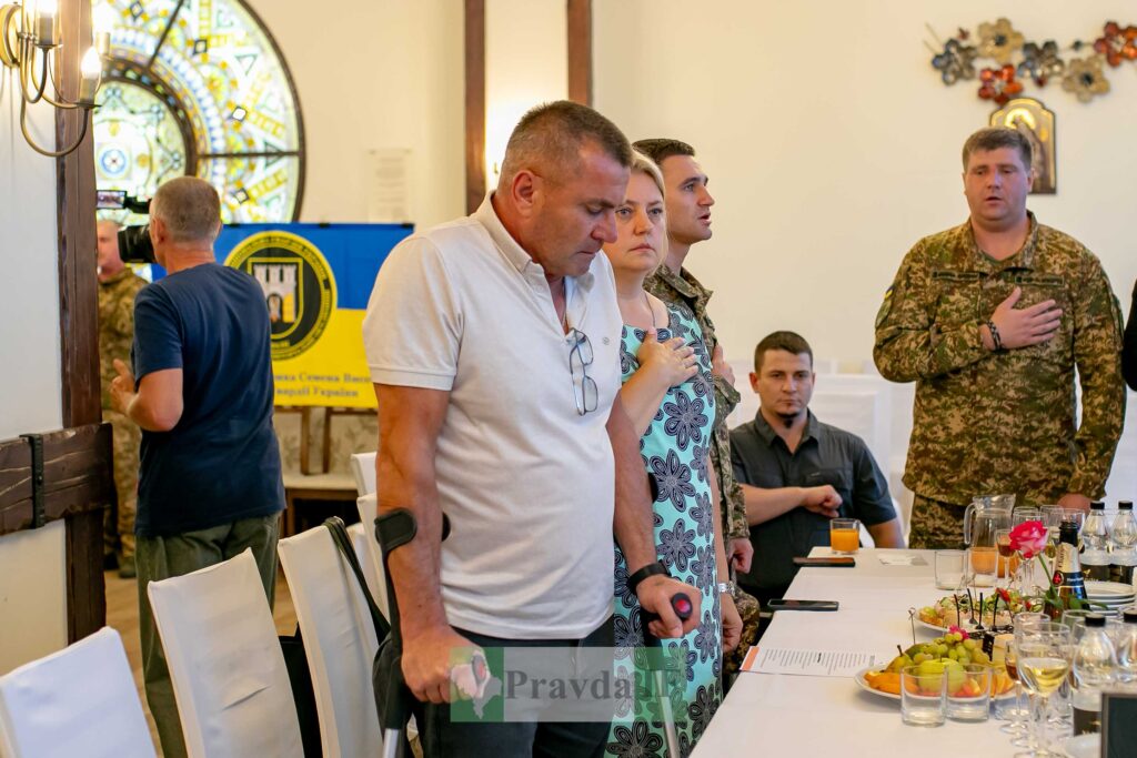 Учасники заходу зібрались за столом з їжею.