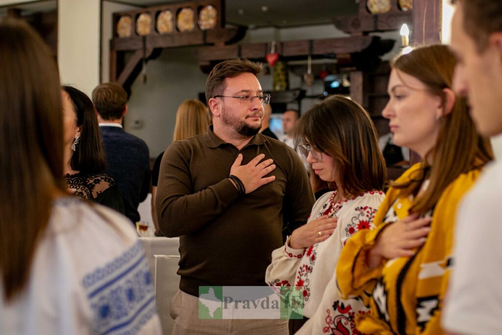 Люди з рукою на грудях у традиційному вбранні.