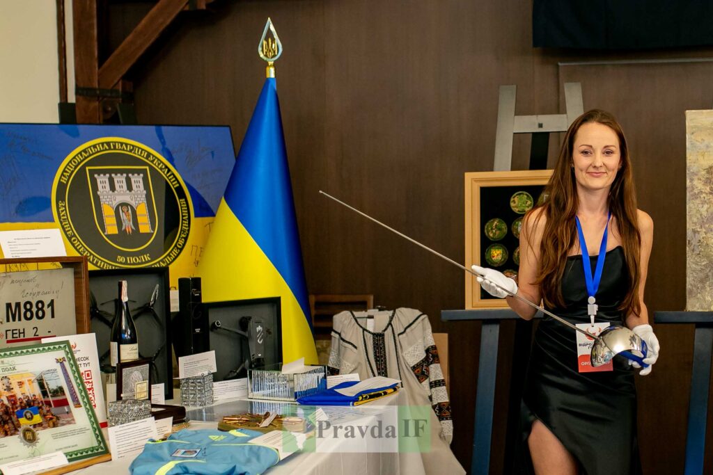 Жінка з шаблею біля українських артефактів.
