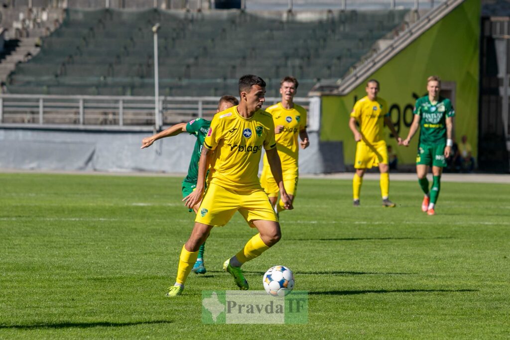 Футболісти грають на полі в жовтій формі.