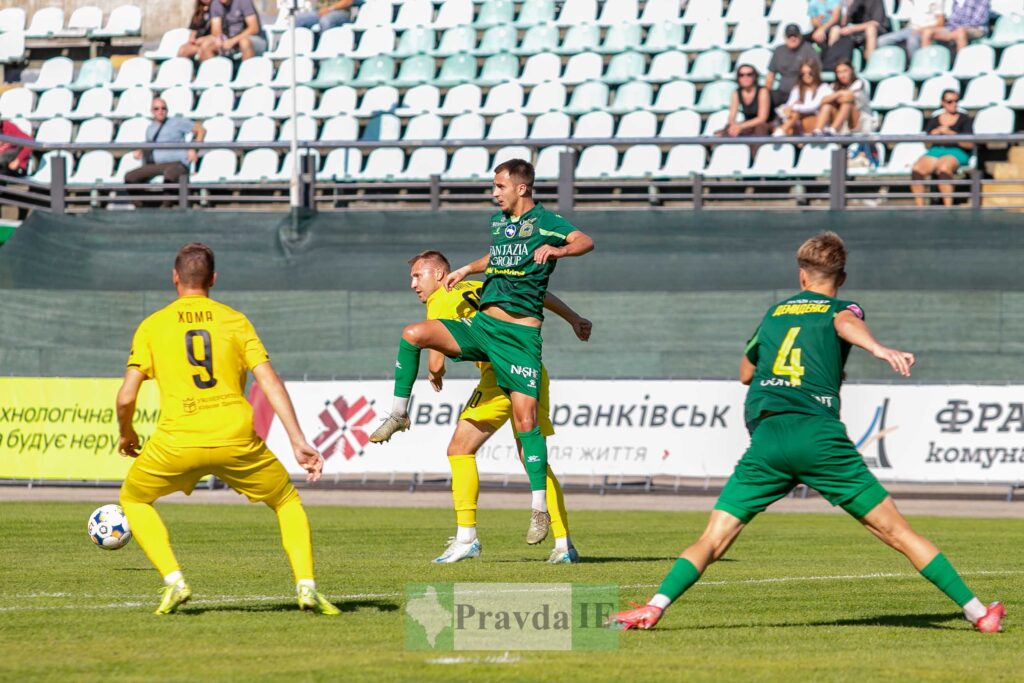 Футбольний матч на стадіоні, гравці на полі.