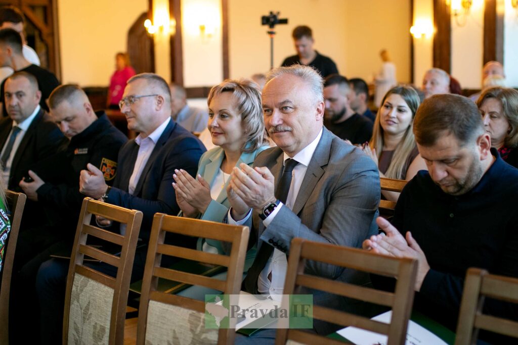 Група людей аплодує на офіційному заході.
