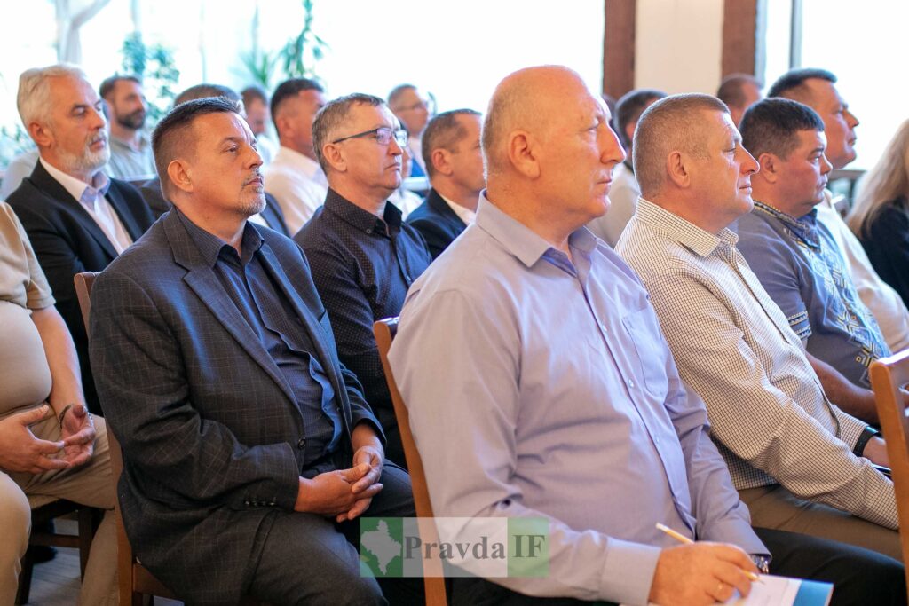 Група людей сидить на конференції у залі.