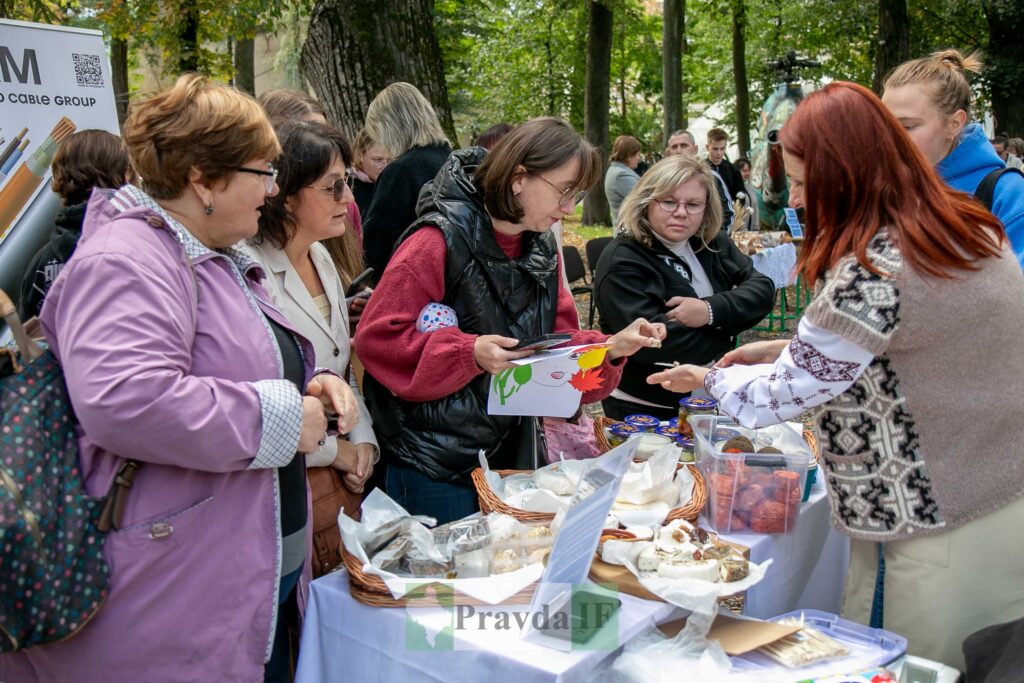 Люди купують продукти на ярмарку на вулиці.