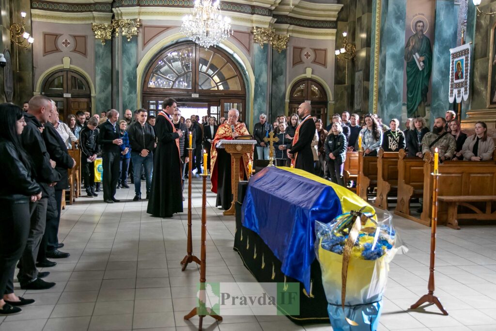 Церемонія прощання з військовим у церкві, люди присутні.