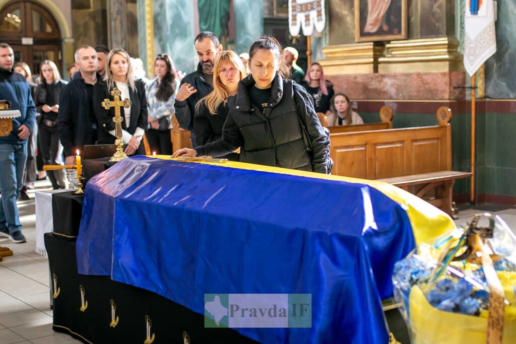 Люди прощаються біля труни, церковна церемонія