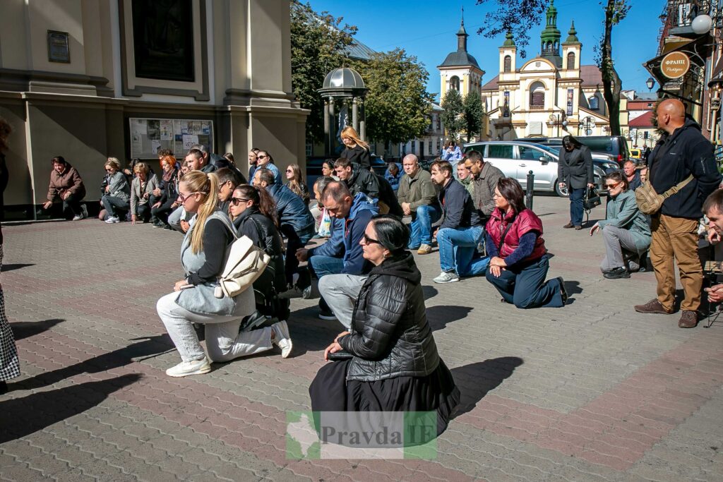Люди моляться на вулиці біля церкви.