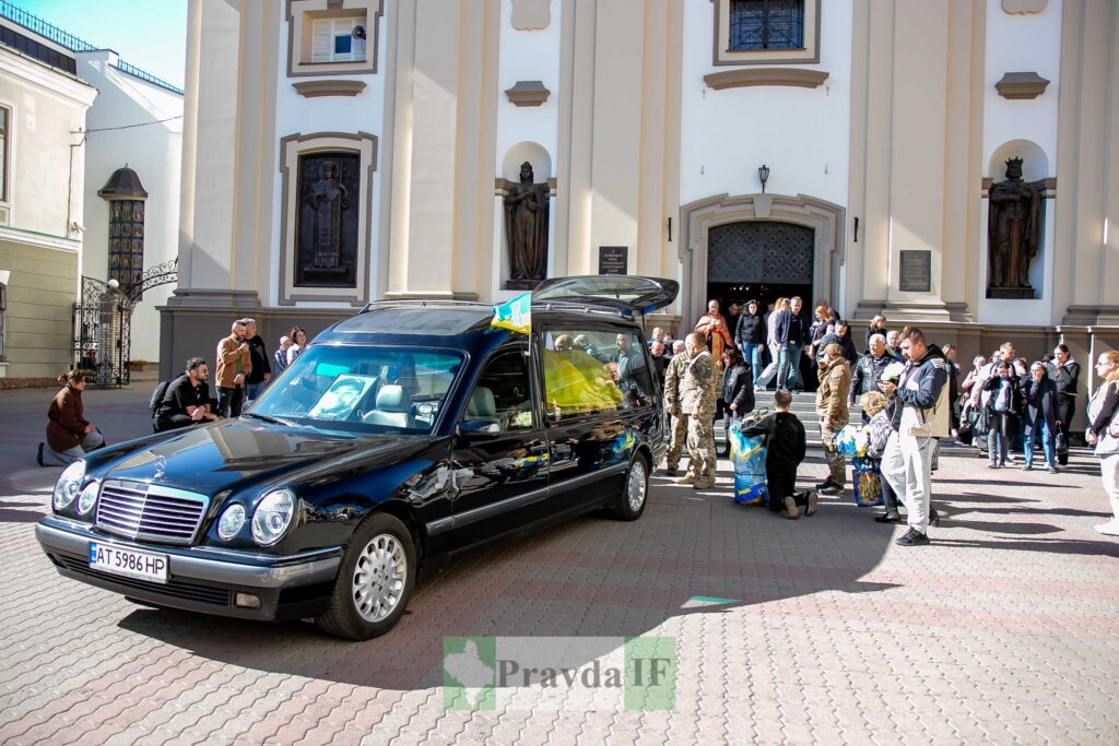 Траурна церемонія біля церкви, похоронний катафалк.