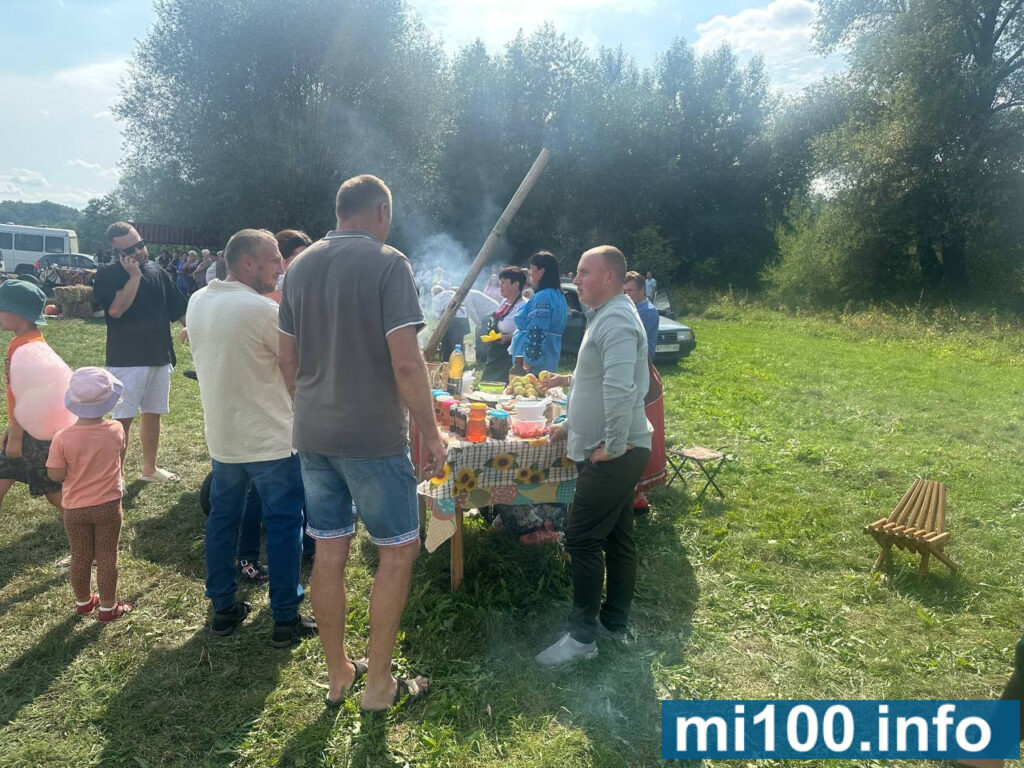 Люди на пікніку в парку, столик з їжею.