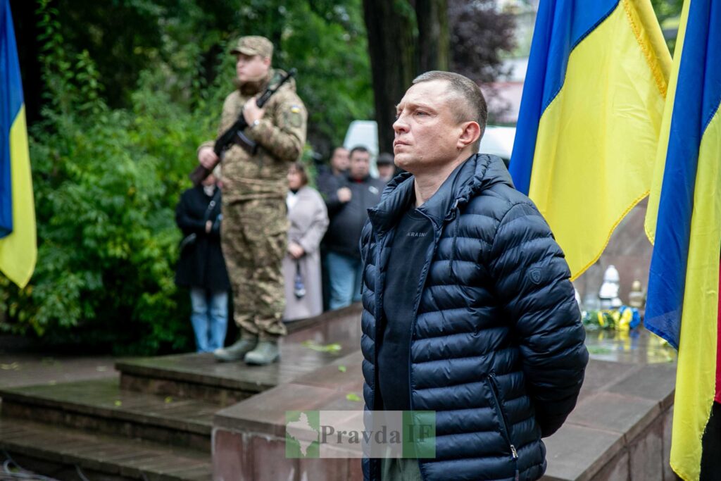 Український солдат на церемонії із прапором України.