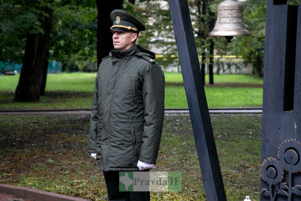 Військовий біля дзвону у парку, осінь