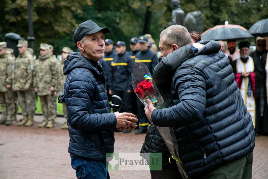 Люди з квітами на вулиці в дощовий день