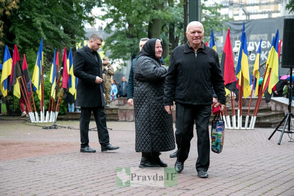 Люди на вулиці з українськими прапорами.
