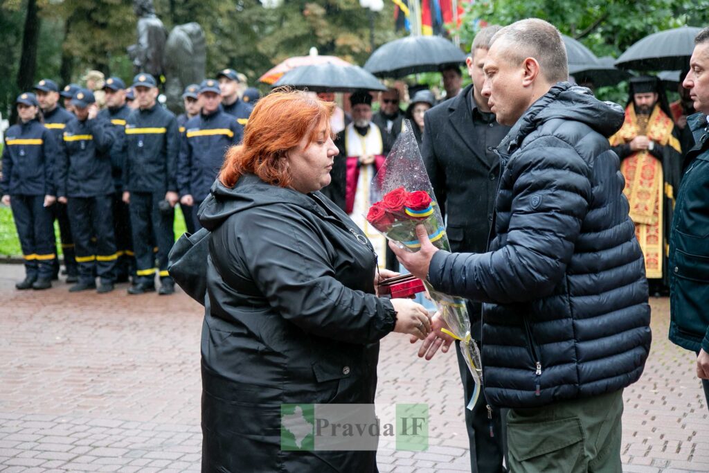 Церемонія вручення квітів у дощовий день.