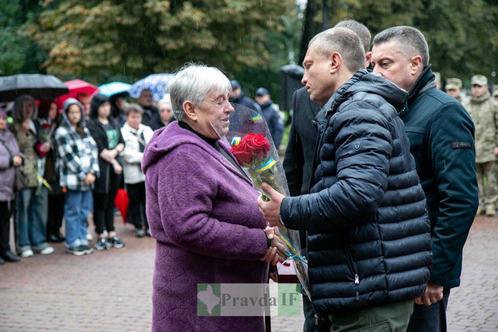 Вшанування пам'яті героя у дощовий день.