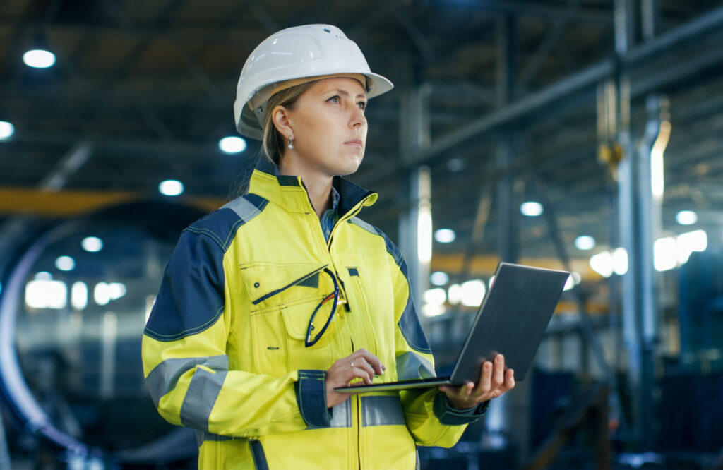 Інженерка з ноутбуком на заводі