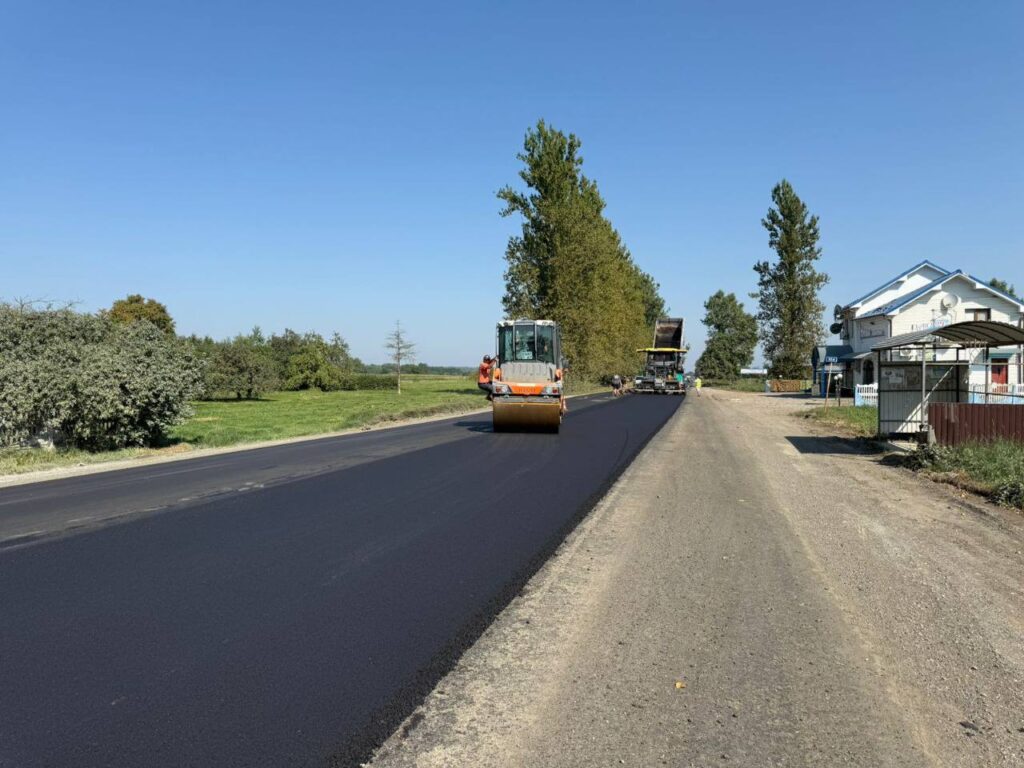 Асфальтування дороги в селі, робота техніки.