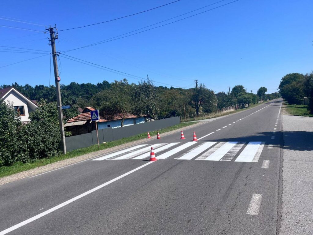 Пішохідний перехід з дорожніми конусами на дорозі.