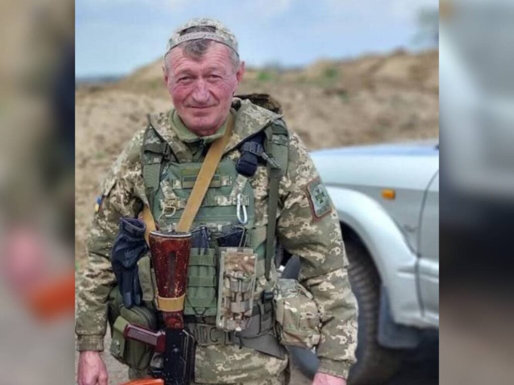 Український військовий у камуфляжі на фоні автомобіля.