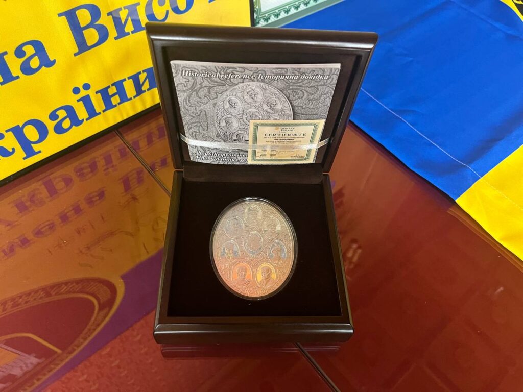 Пам'ятна монета у футлярі на тлі прапора