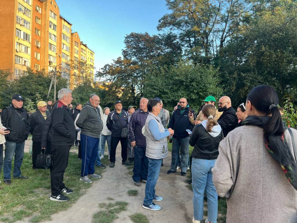 Група людей на вулиці біля багатоповерхівки