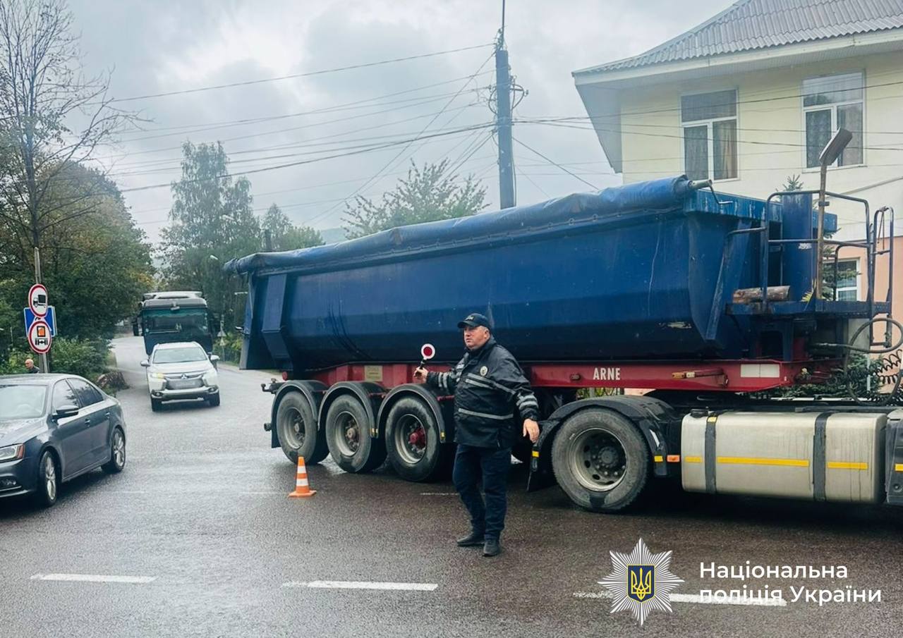 Поліцейський регулює рух біля вантажівки на дорозі