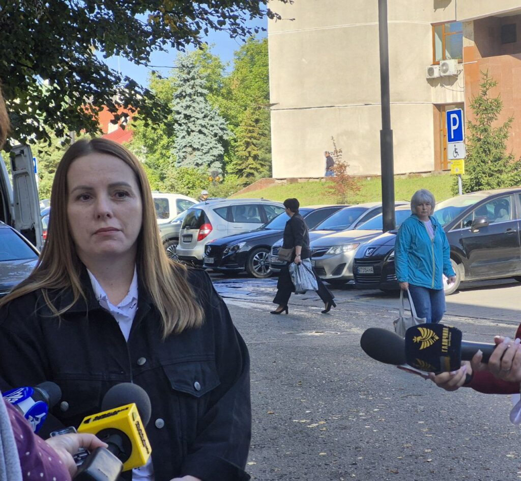 Жінка під час вуличного інтерв'ю біля автостоянки.