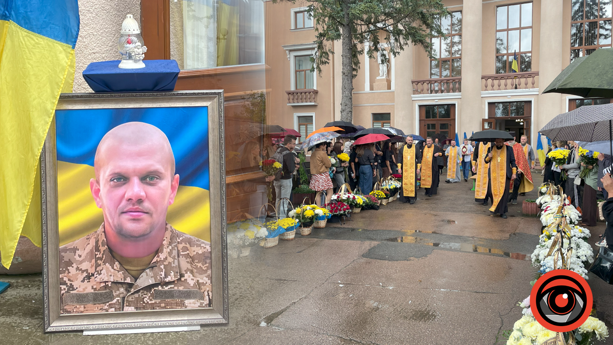 Прощання з героєм на тлі українського прапора.