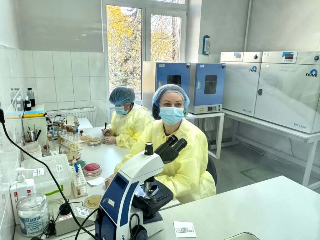 Науковці працюють у лабораторії з мікроскопом