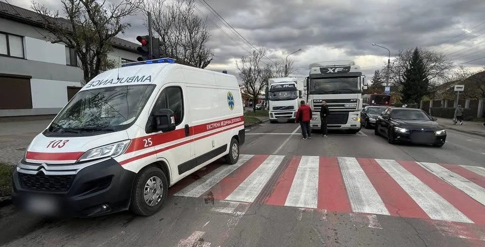 Швидка допомога та вантажівки на міській дорозі