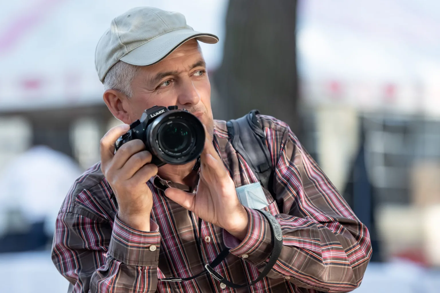 Фотограф тримає камеру на відкритому повітрі