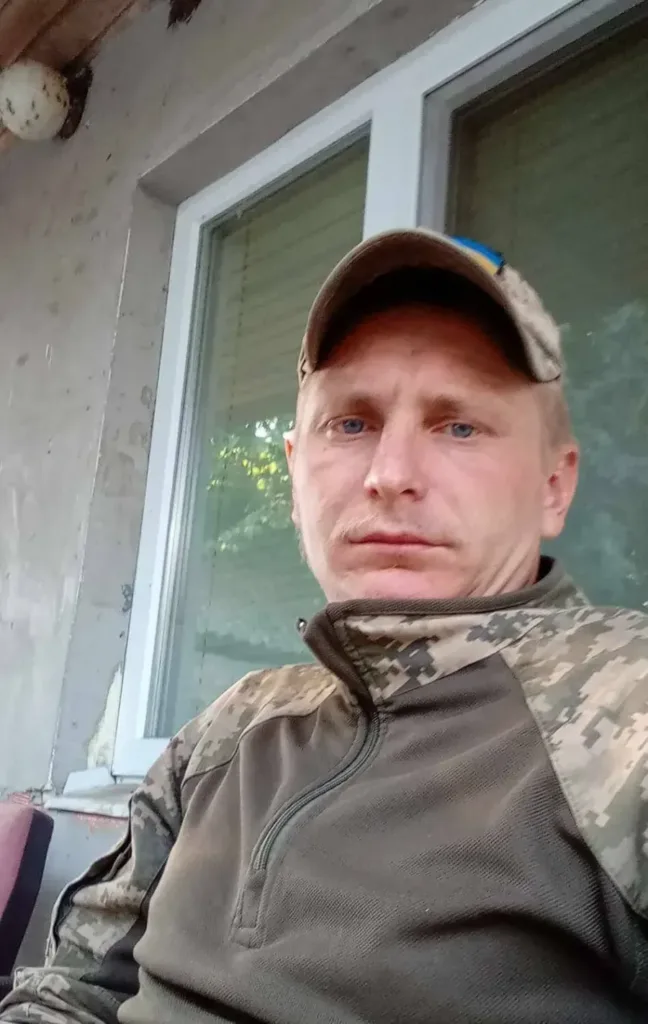 Військовий у камуфляжі сидить біля вікна