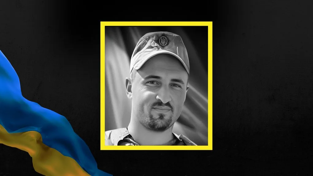 Український військовий у формі на чорному тлі